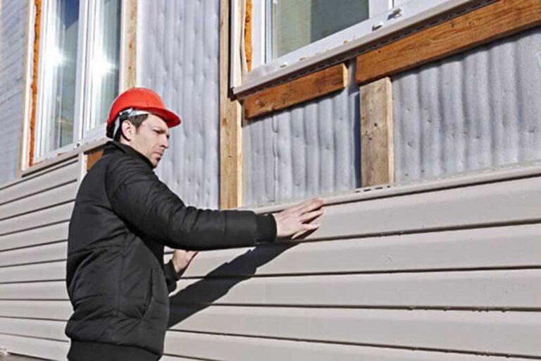 man installing new vinyl siding on house
