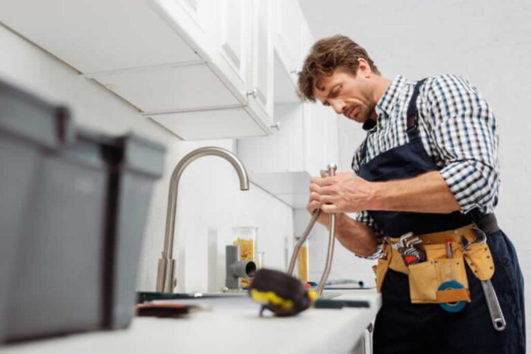 handyman repairing faucet in rental property