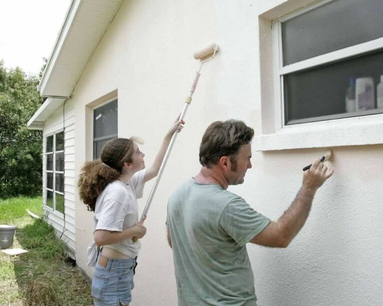 couple painting exterior wall
