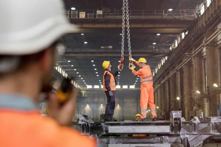 two workers managing the crane in the warehouse