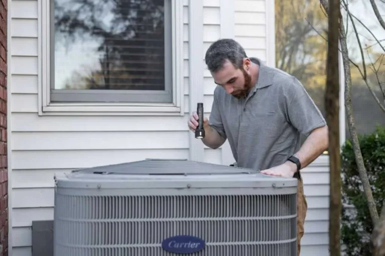 man checking up heat pump outside unit