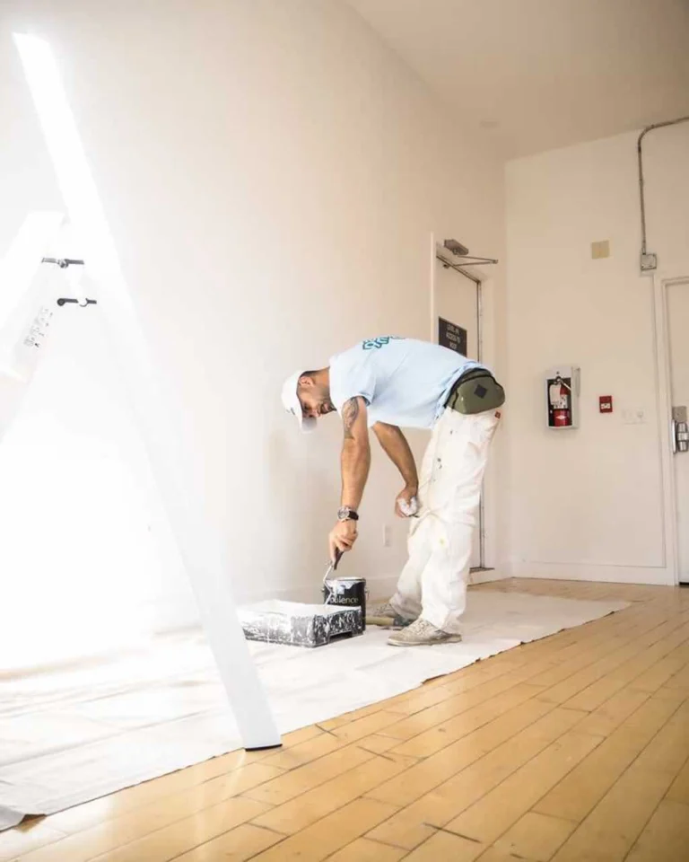 painter grabbing paint to paint a wall in condo