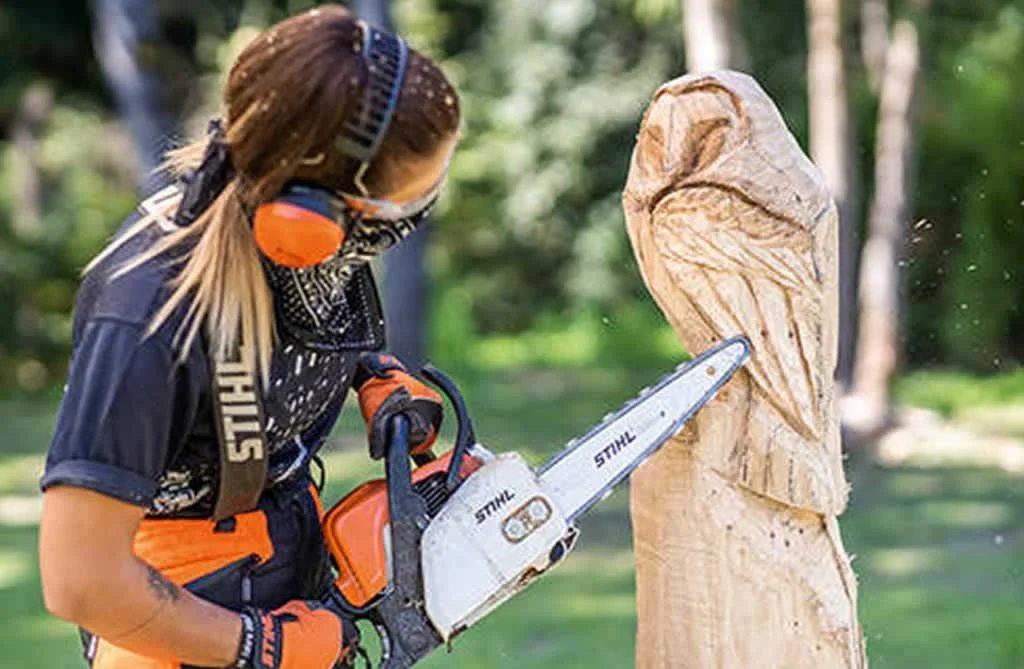 finishing carving an owl with chainsaw