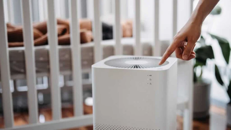 hand turning on air purifier in home
