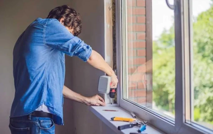 man replacing window in his home