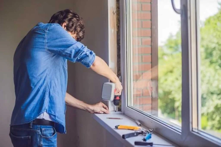man replacing window in his home