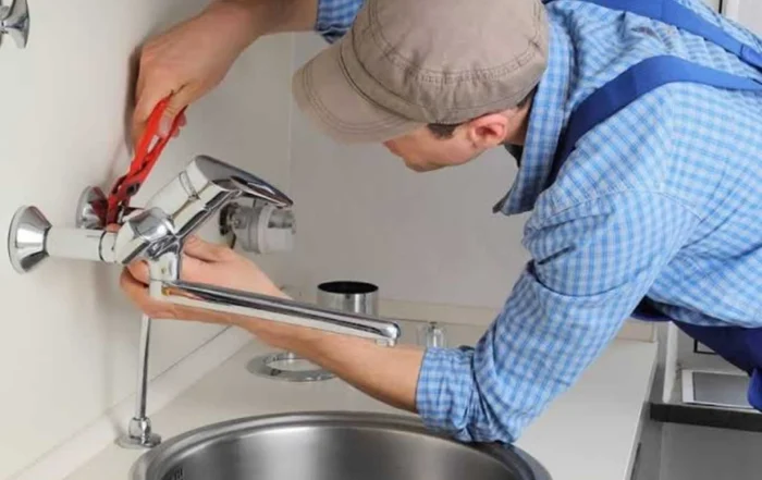 plumber fixing the faucet in the bathroom