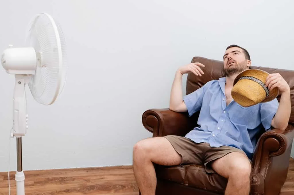 man cooling in front of a fan with AC down