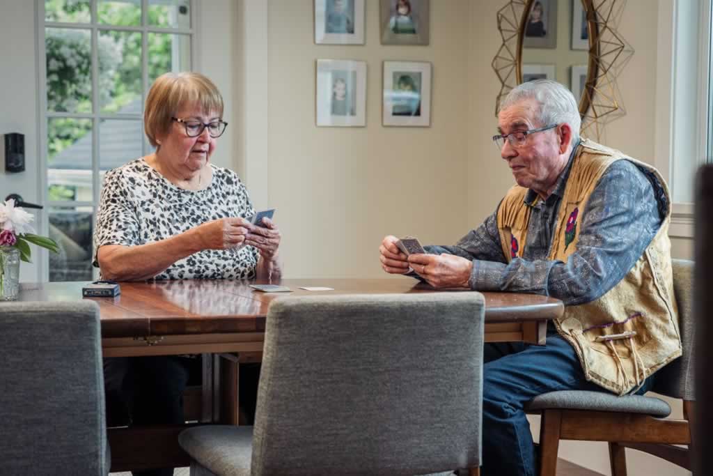 elderly couple playing cards in safe living environment